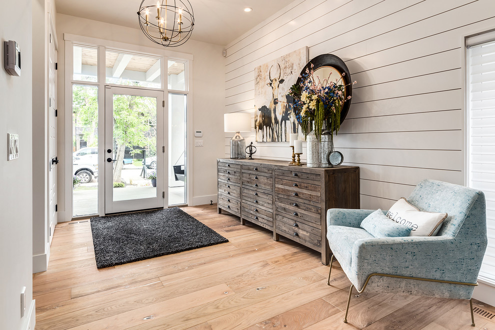 Großes Landhausstil Foyer mit weißer Wandfarbe, hellem Holzboden, Einzeltür, beigem Boden und Haustür aus Glas in Calgary