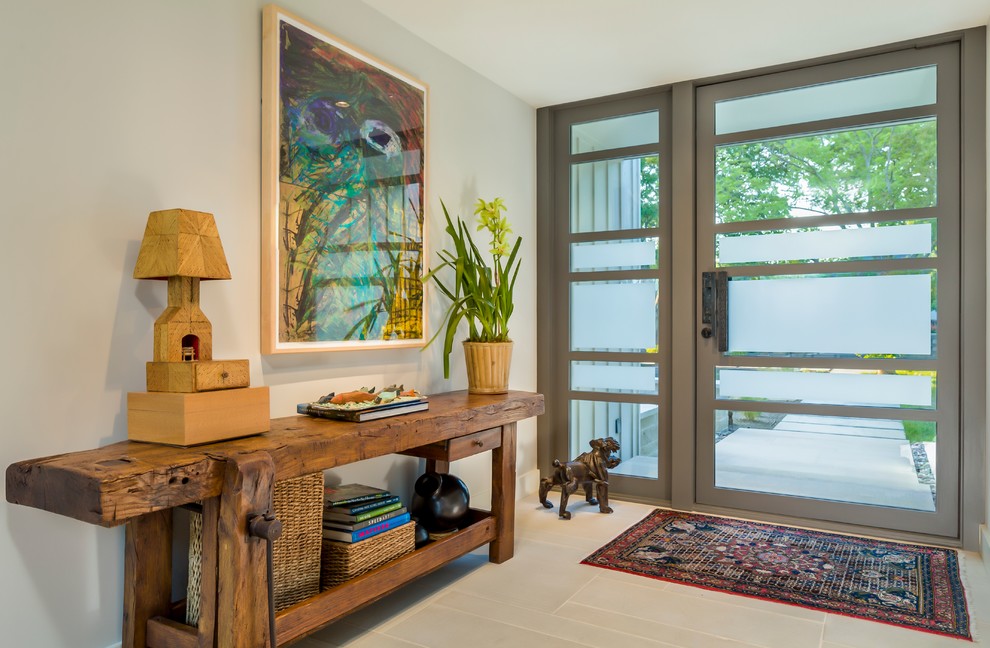 Imagen de entrada campestre de tamaño medio con paredes grises, puerta simple y puerta de vidrio