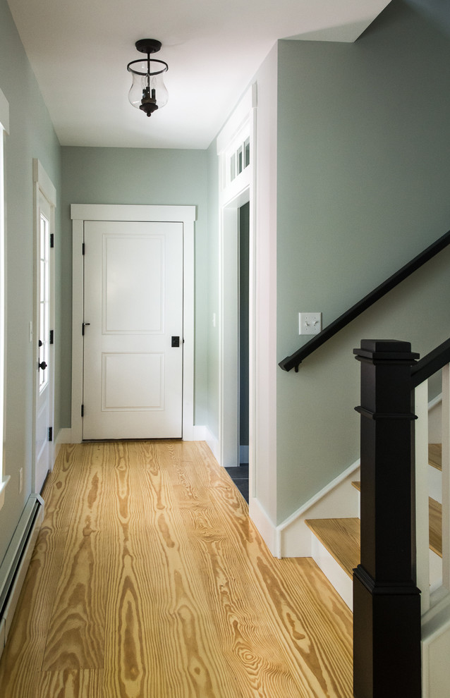 Modelo de entrada de estilo de casa de campo de tamaño medio con paredes grises, suelo de madera clara, puerta simple, puerta de madera en tonos medios y suelo marrón