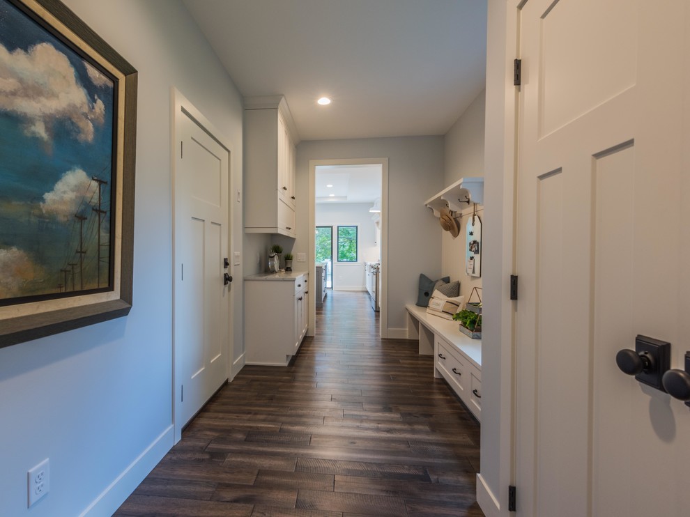 This is an example of a medium sized country boot room in Minneapolis with grey walls, medium hardwood flooring, a single front door, a white front door and brown floors.