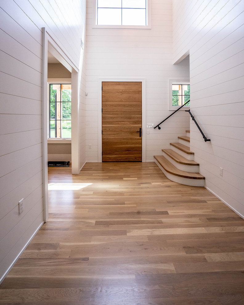 Foto de distribuidor de estilo de casa de campo de tamaño medio con paredes blancas, suelo de madera clara, puerta simple, puerta de madera en tonos medios y suelo marrón