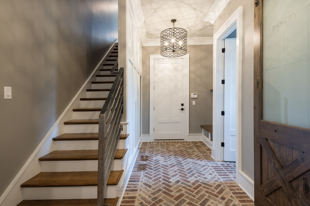 Inspiration for a mid-sized country brick floor and brown floor entryway remodel in Atlanta with gray walls and a white front door