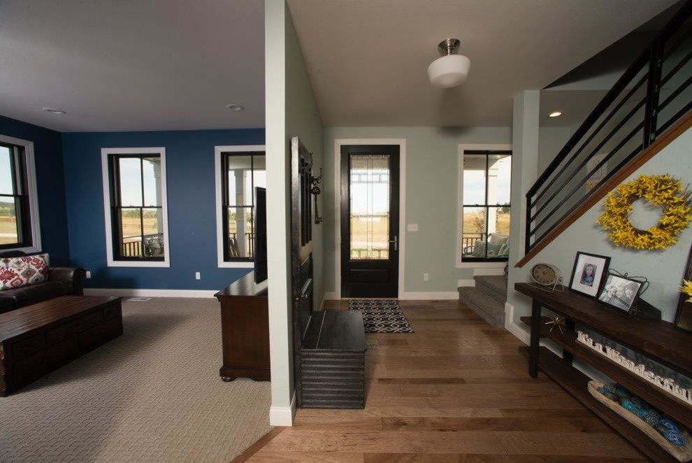 Imagen de distribuidor de estilo de casa de campo de tamaño medio con paredes grises, suelo de madera en tonos medios, puerta simple, puerta de vidrio y suelo marrón