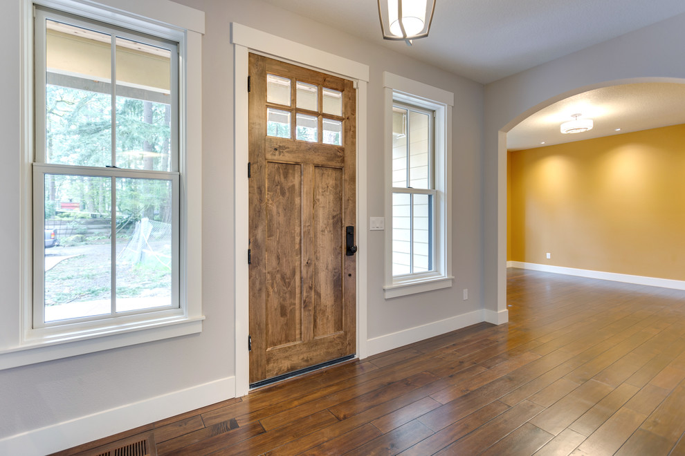 Design ideas for a medium sized rural front door in Salt Lake City with grey walls, dark hardwood flooring, a single front door, a medium wood front door and brown floors.