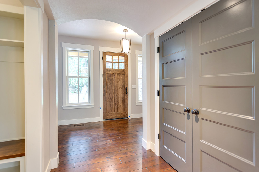 Imagen de puerta principal de estilo de casa de campo de tamaño medio con paredes grises, suelo de madera oscura, puerta simple, puerta de madera en tonos medios y suelo marrón