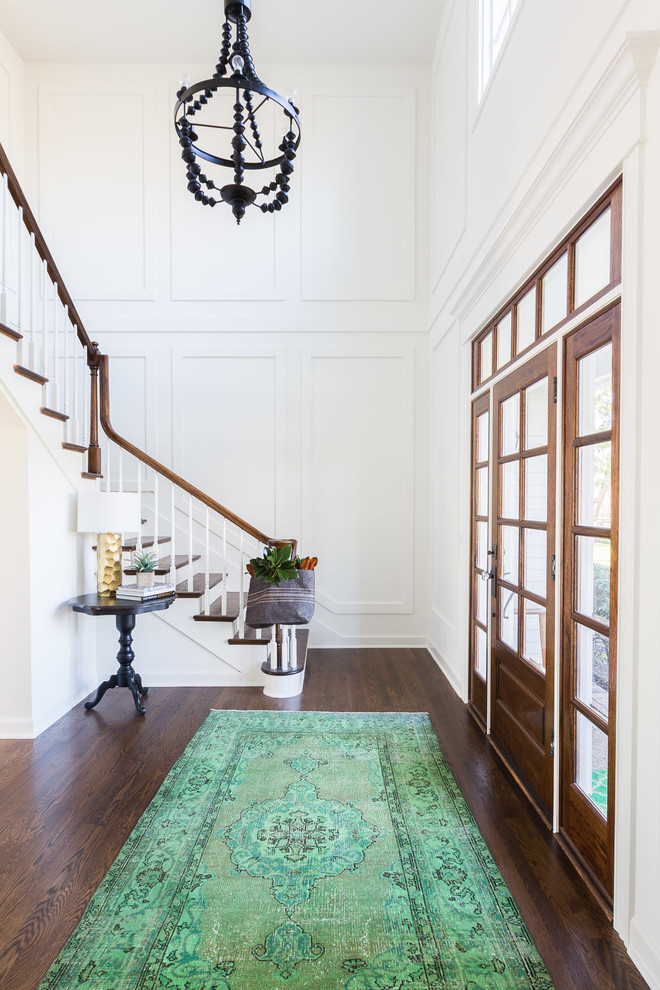 Transitional dark wood floor entryway photo in Nashville with white walls and a dark wood front door