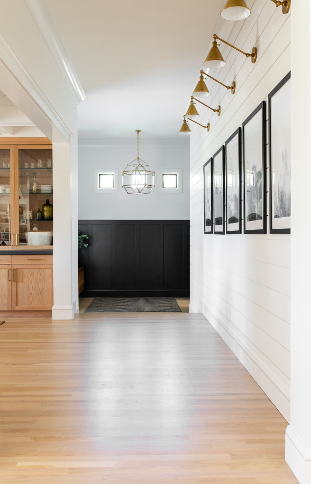 Inspiration for a farmhouse hallway in Sacramento with black walls, light hardwood flooring, a single front door and a black front door.