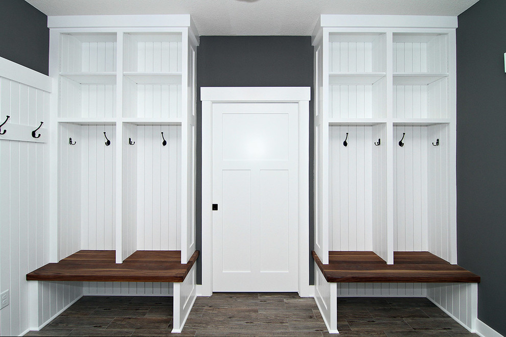 Idée de décoration pour une entrée minimaliste de taille moyenne avec un vestiaire, un mur gris, un sol en carrelage de céramique, une porte simple et une porte blanche.
