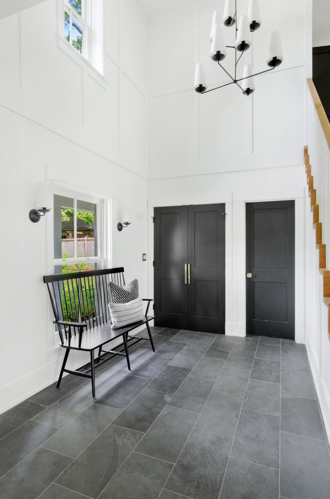 Стильный дизайн: фойе среднего размера в современном стиле с белыми стенами, полом из сланца, одностворчатой входной дверью, черной входной дверью, серым полом, сводчатым потолком и панелями на части стены - последний тренд