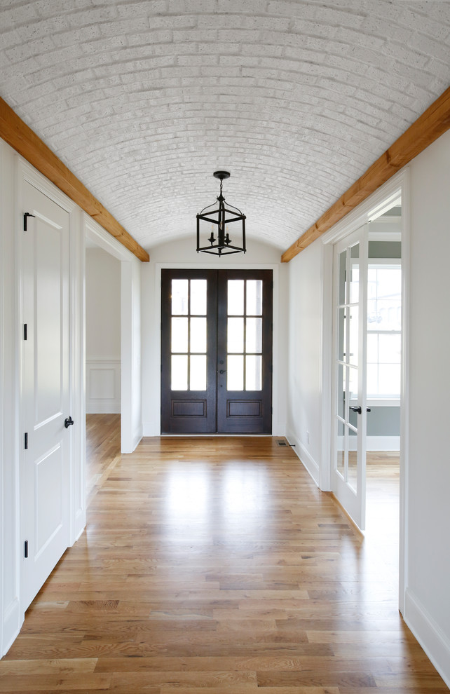 Double front door - mid-sized country light wood floor and multicolored floor double front door idea in Nashville with white walls and a black front door