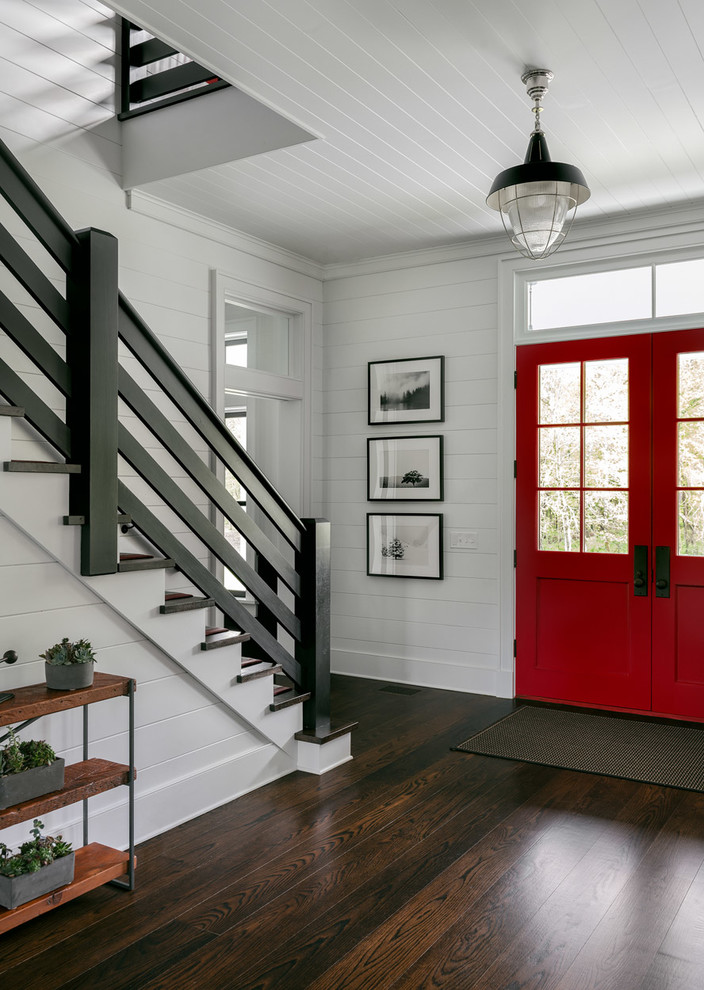 Großes Landhausstil Foyer mit weißer Wandfarbe, dunklem Holzboden, Doppeltür, roter Haustür und braunem Boden in New York