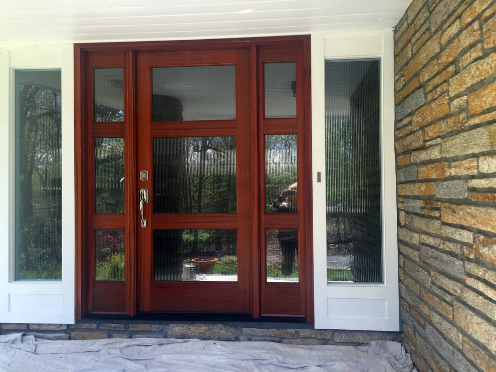 Exemple d'une entrée tendance avec une porte simple et une porte en bois brun.
