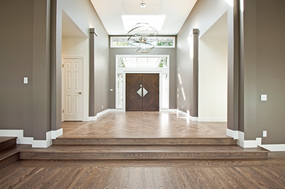Foto di un grande corridoio minimal con pareti marroni, pavimento in legno massello medio, una porta a due ante, una porta marrone e pavimento marrone