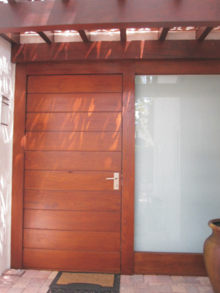 Идея дизайна: входная дверь в стиле модернизм с одностворчатой входной дверью и входной дверью из дерева среднего тона