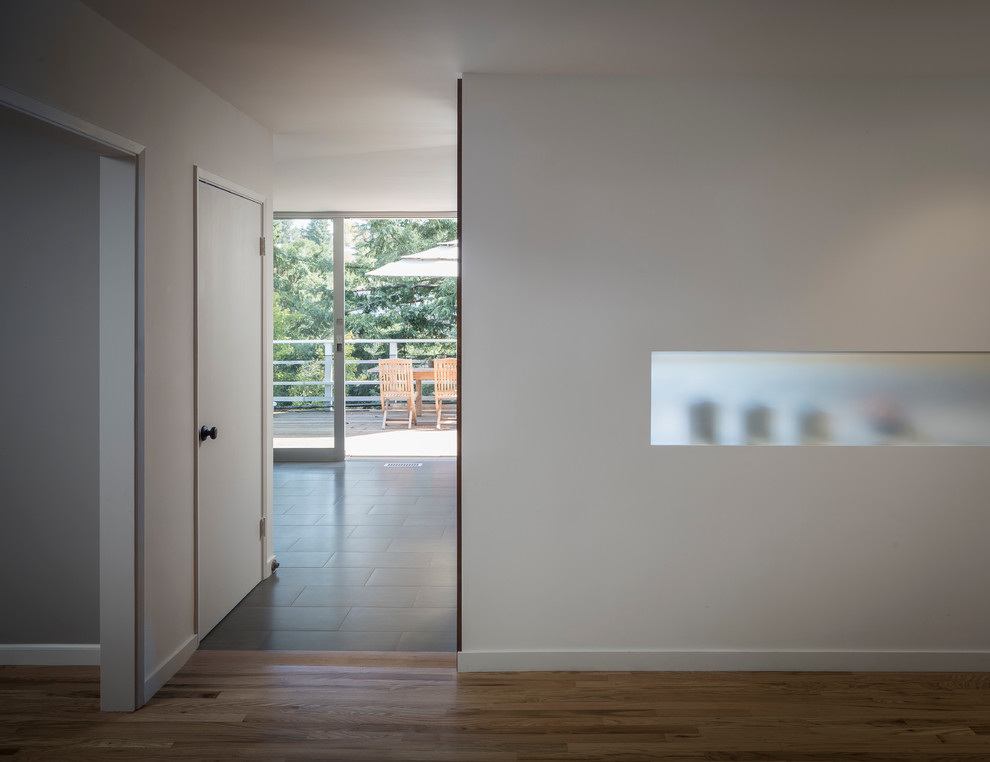 This is an example of a large modern foyer in San Francisco with white walls and medium hardwood flooring.