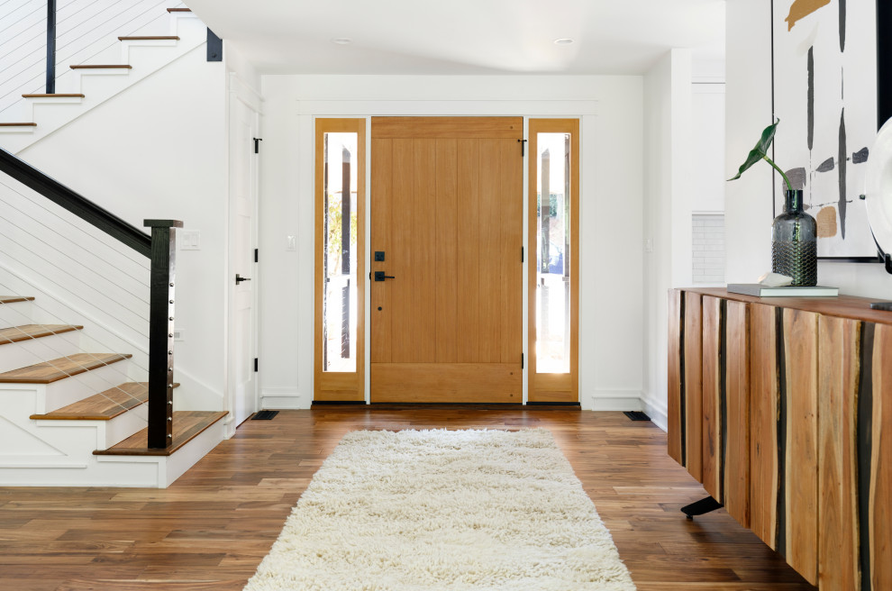 Foto de distribuidor campestre de tamaño medio con paredes blancas, suelo de madera en tonos medios, puerta simple y puerta de madera en tonos medios