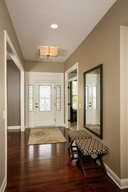 Ejemplo de entrada contemporánea con paredes grises, suelo de madera en tonos medios, puerta simple y puerta blanca