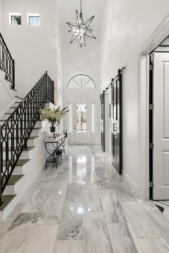 Réalisation d'un hall d'entrée minimaliste de taille moyenne avec un mur blanc, un sol en marbre, une porte simple, une porte blanche et un sol blanc.