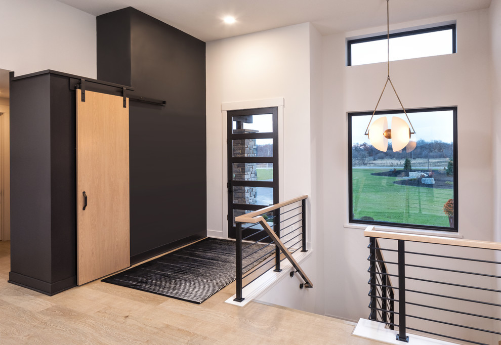 Inspiration for a mid-sized modern entryway remodel in Minneapolis with black walls and a medium wood front door