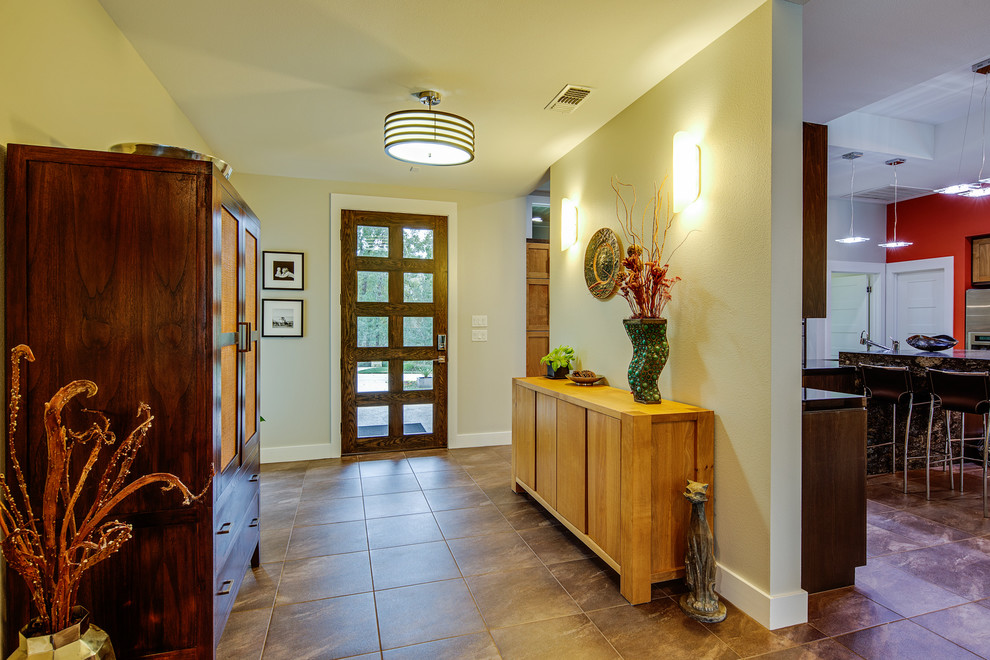 Inspiration pour une entrée minimaliste de taille moyenne avec un couloir, un mur gris, un sol en carrelage de céramique, une porte simple et une porte en bois foncé.