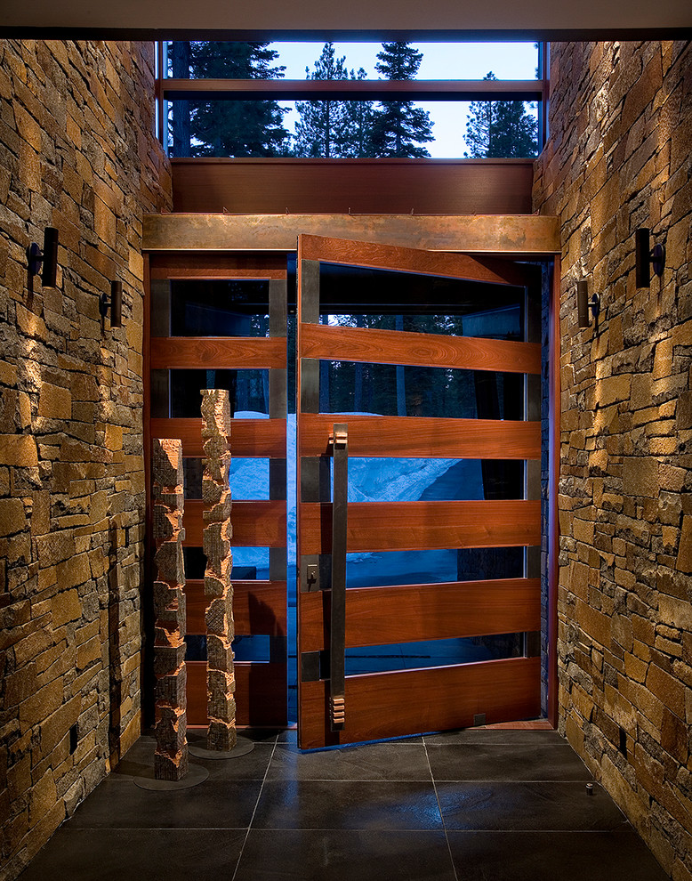 Источник вдохновения для домашнего уюта: большая входная дверь в стиле модернизм с коричневыми стенами, входной дверью из дерева среднего тона и серым полом