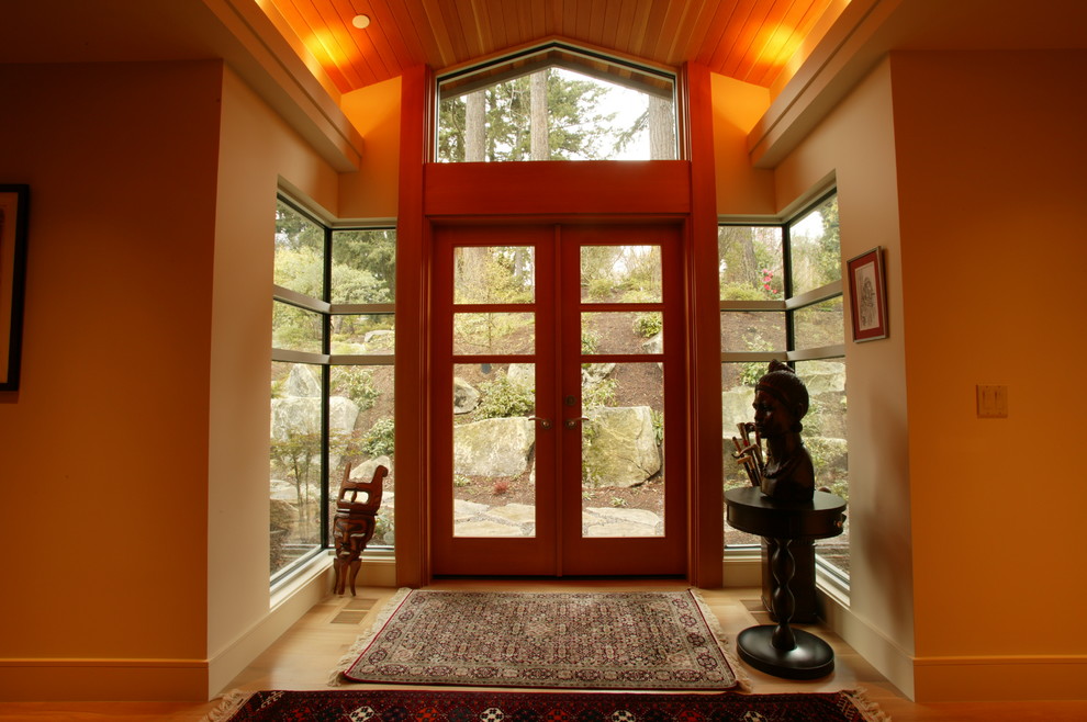 Exemple d'une très grande entrée tendance avec un couloir, un mur beige, un sol en bois brun, une porte double et une porte en bois brun.