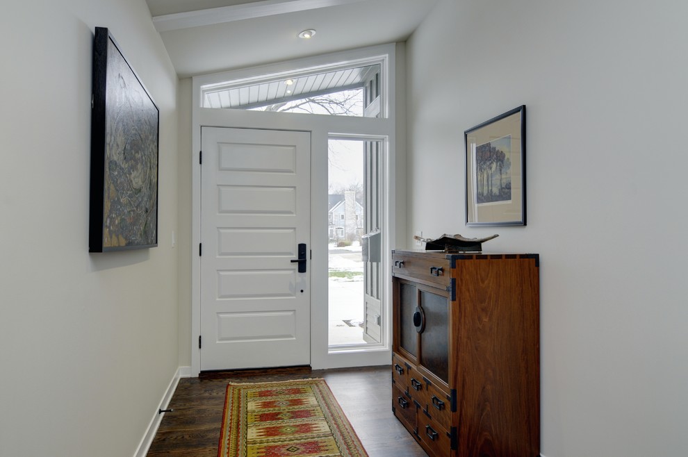 Diseño de hall contemporáneo con paredes blancas, suelo de madera oscura, puerta simple y puerta blanca
