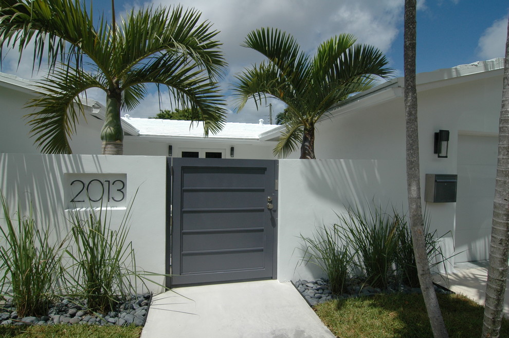 マイアミにあるトロピカルスタイルのおしゃれな玄関 (白い壁) の写真