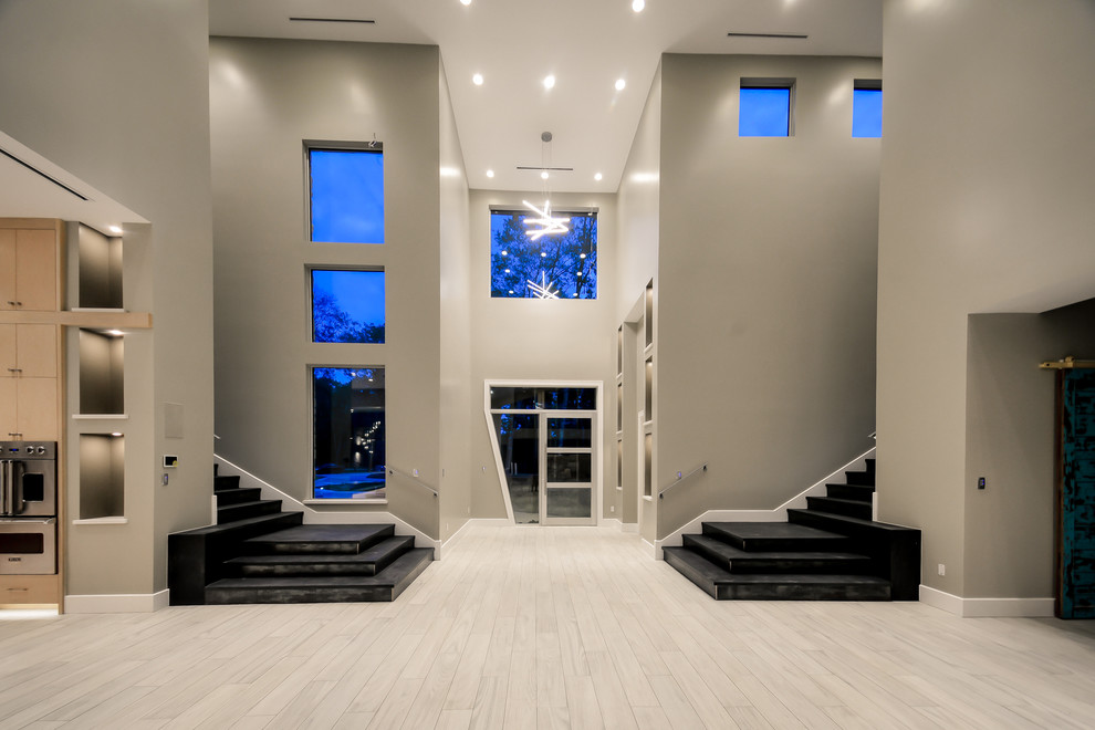 На фото: огромный вестибюль в современном стиле с серыми стенами, полом из керамогранита, одностворчатой входной дверью и стеклянной входной дверью