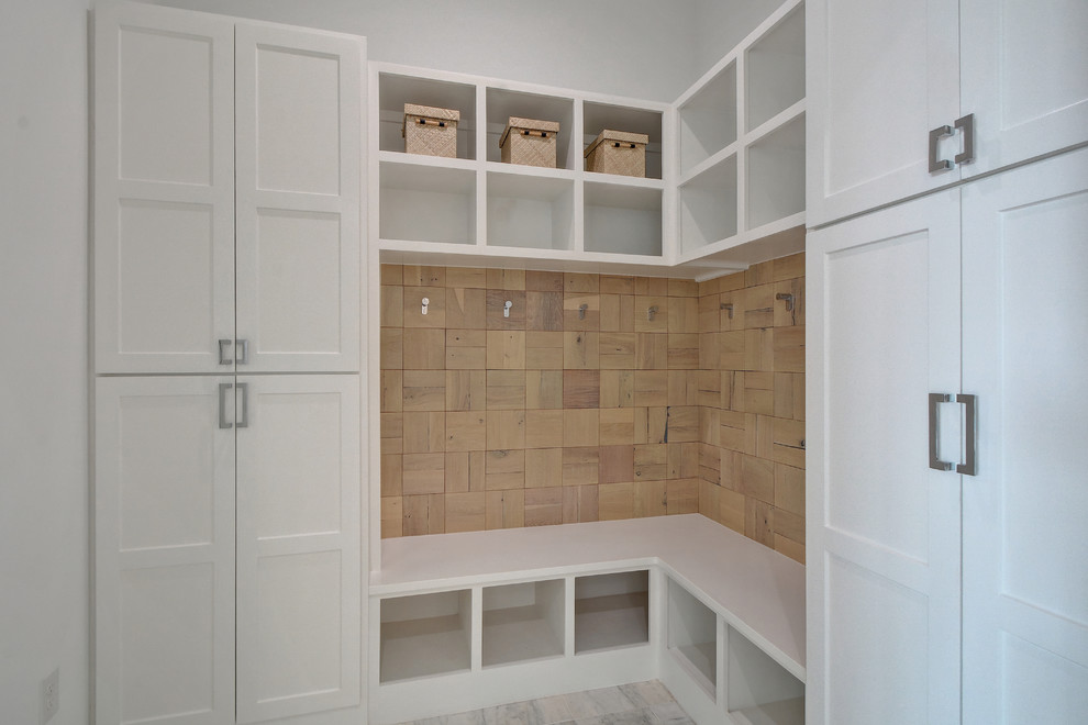 Inspiration pour une entrée traditionnelle de taille moyenne avec un vestiaire, un mur blanc et un sol en bois brun.