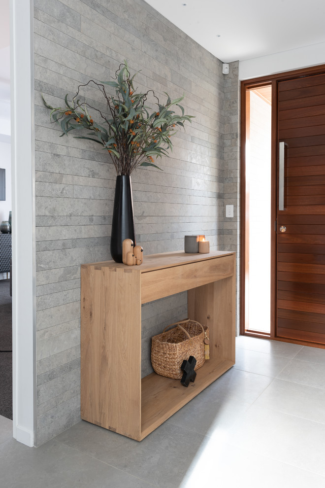 Inspiration för minimalistiska foajéer, med en enkeldörr, mörk trädörr och grått golv