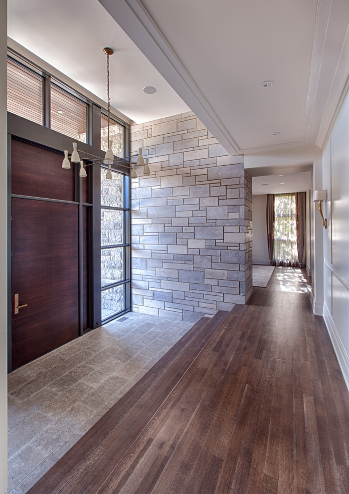 Imagen de entrada minimalista grande con puerta simple, paredes blancas, suelo de madera oscura y puerta de madera oscura