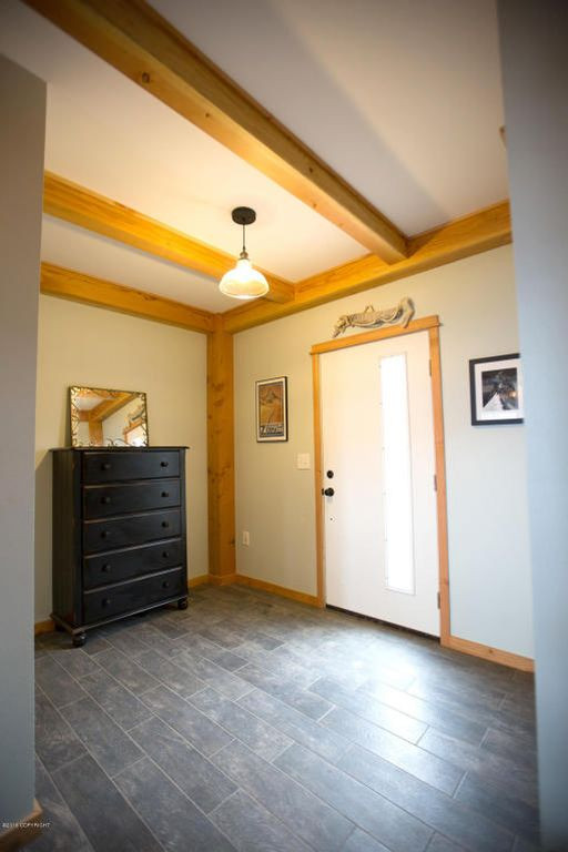 Großer Landhausstil Eingang mit Stauraum, gelber Wandfarbe, Keramikboden, Einzeltür, weißer Haustür, schwarzem Boden, Holzdecke und Holzwänden in Sonstige