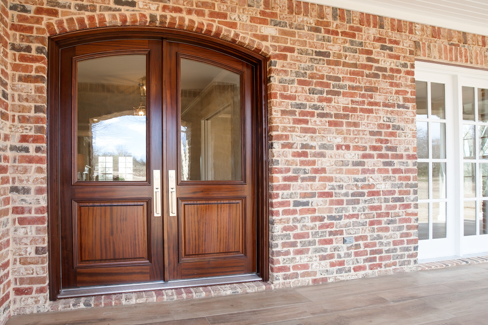 Foto de puerta principal clásica grande con suelo de baldosas de porcelana, puerta doble y puerta de madera oscura