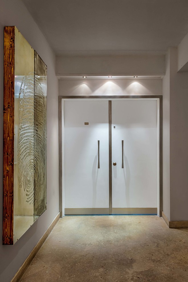 Foto di un ingresso minimalista di medie dimensioni con pareti bianche, pavimento in travertino, una porta a due ante e una porta bianca