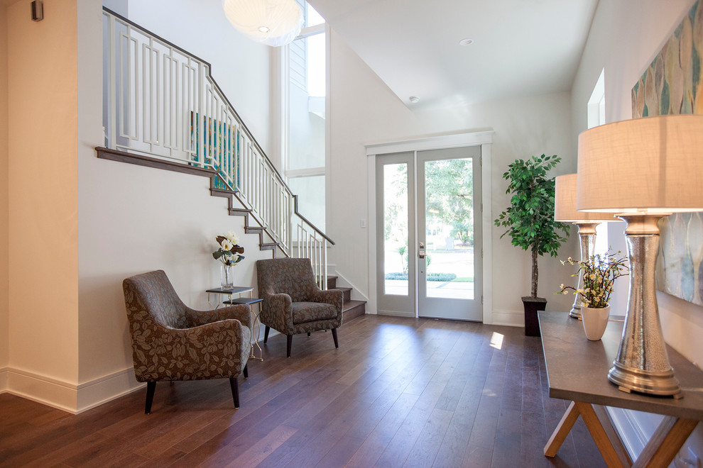 Design ideas for a medium sized contemporary foyer in Orlando with white walls, medium hardwood flooring, a single front door, a glass front door and feature lighting.