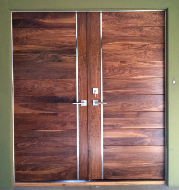 Modelo de puerta principal contemporánea grande con paredes verdes, suelo de madera clara, puerta doble y puerta de madera en tonos medios