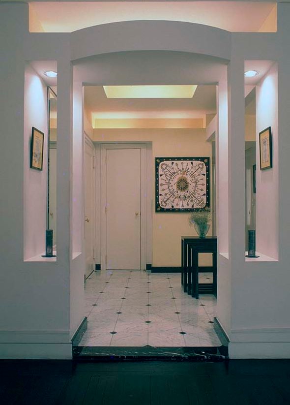 Cette photo montre un très grand hall d'entrée moderne avec un mur blanc, un sol en marbre, une porte simple et une porte blanche.