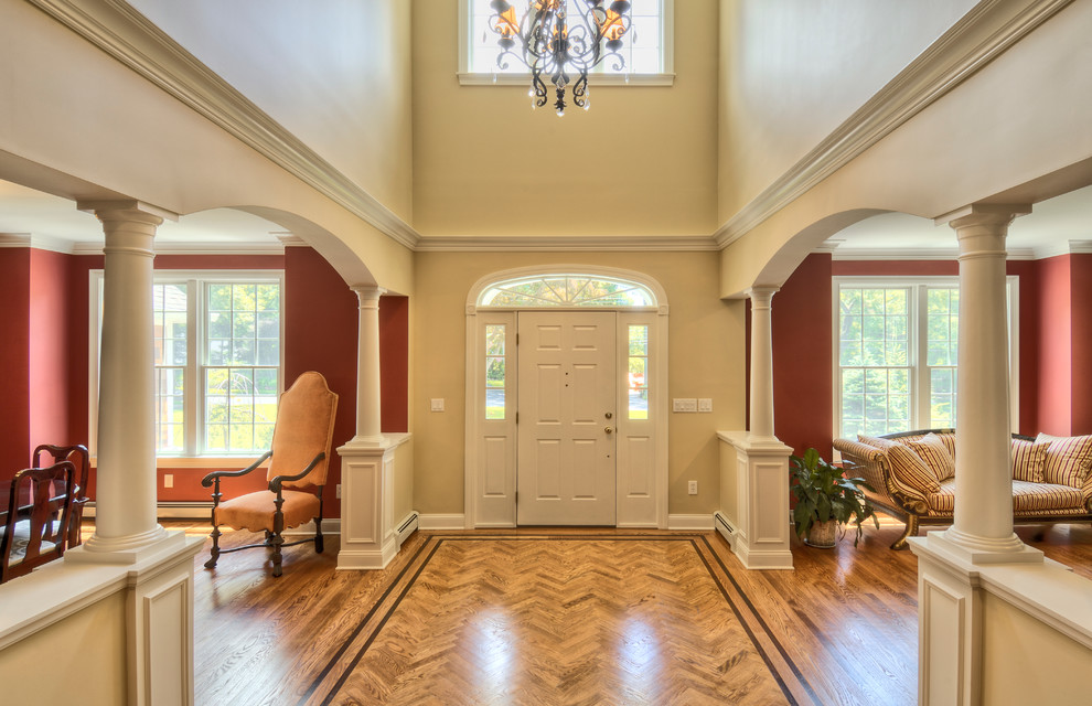 Photo of an expansive classic foyer in New York with multi-coloured walls, medium hardwood flooring, a single front door and a white front door.