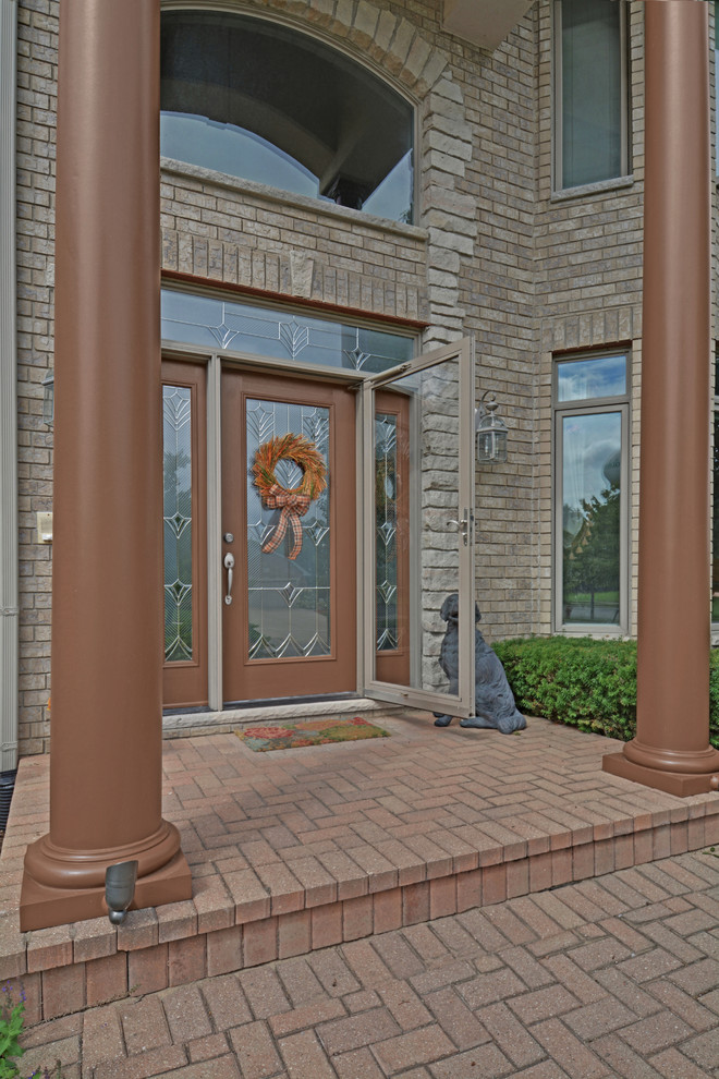 Entryway - large traditional brick floor entryway idea in Chicago with a brown front door