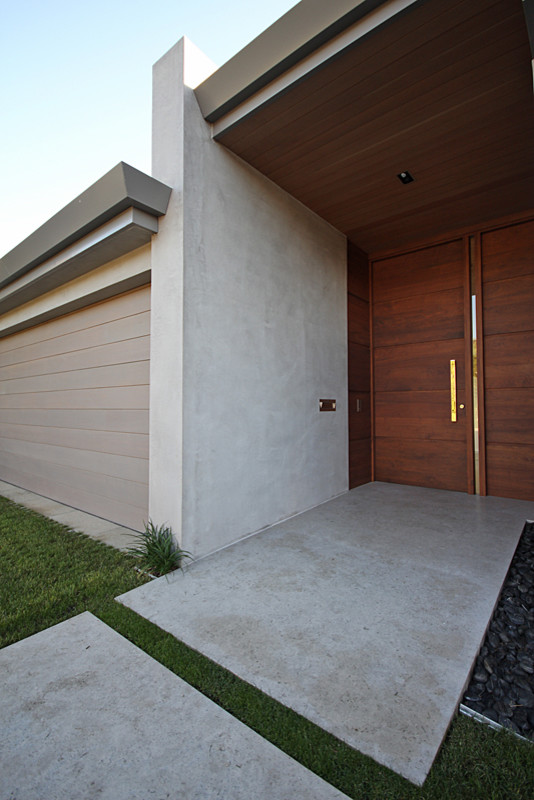 Inspiration pour une grande porte d'entrée design avec un mur blanc, sol en béton ciré, une porte simple et une porte en bois foncé.