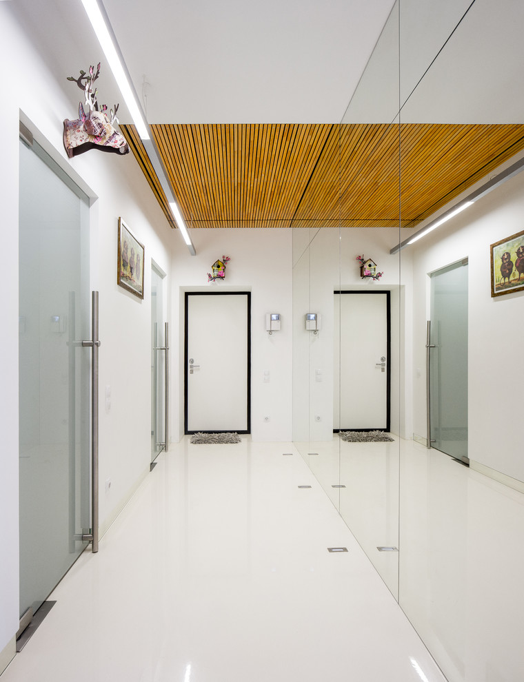 Idées déco pour un hall d'entrée moderne de taille moyenne avec un mur blanc, un sol en vinyl, une porte simple, une porte blanche et un sol blanc.