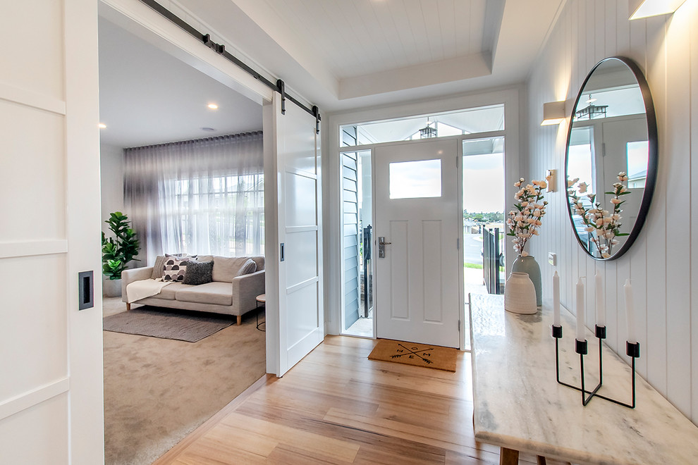 Großes Landhaus Foyer mit weißer Wandfarbe, braunem Holzboden, braunem Boden und weißer Haustür in Melbourne