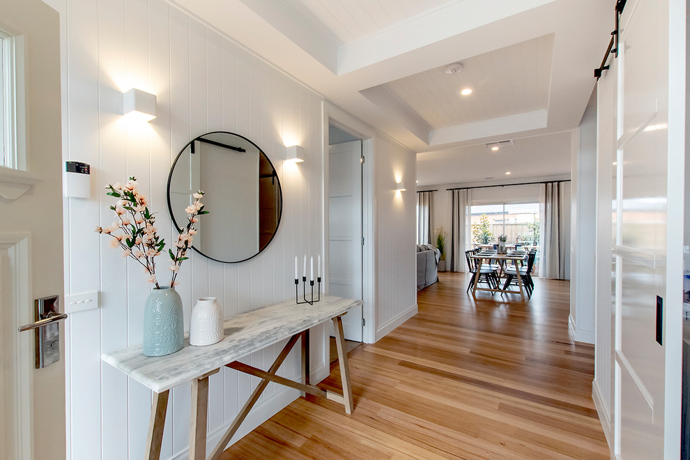 Großes Country Foyer mit weißer Wandfarbe, braunem Holzboden, braunem Boden und weißer Haustür in Melbourne