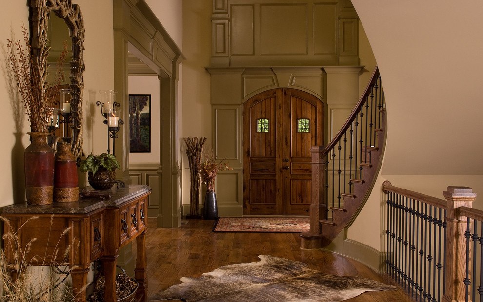 На фото: прихожая в стиле рустика с двустворчатой входной дверью, входной дверью из темного дерева и коричневым полом