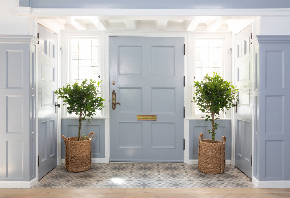 Idée de décoration pour une entrée champêtre avec une porte bleue.