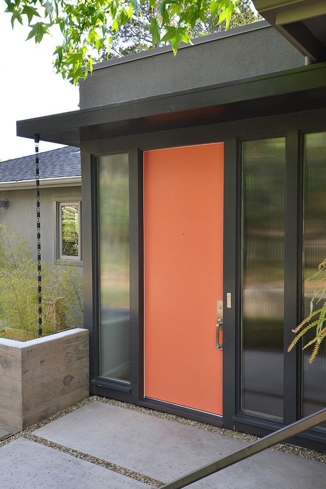Esempio di una porta d'ingresso minimalista di medie dimensioni con pareti beige, pavimento in legno massello medio, una porta singola e una porta arancione