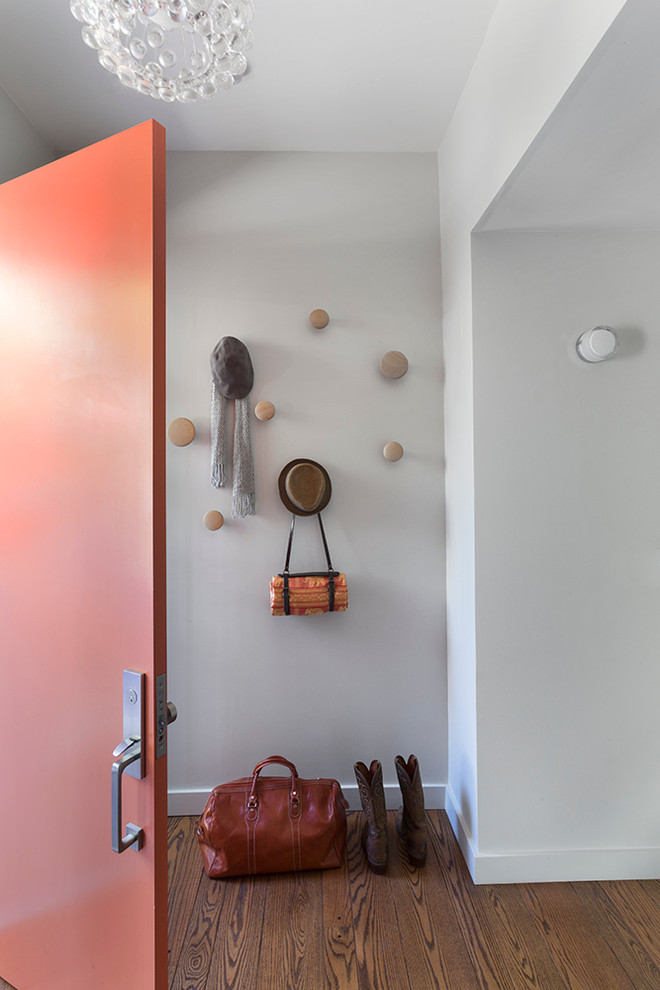 Inredning av en modern mellanstor ingång och ytterdörr, med beige väggar, mellanmörkt trägolv, en enkeldörr och en orange dörr