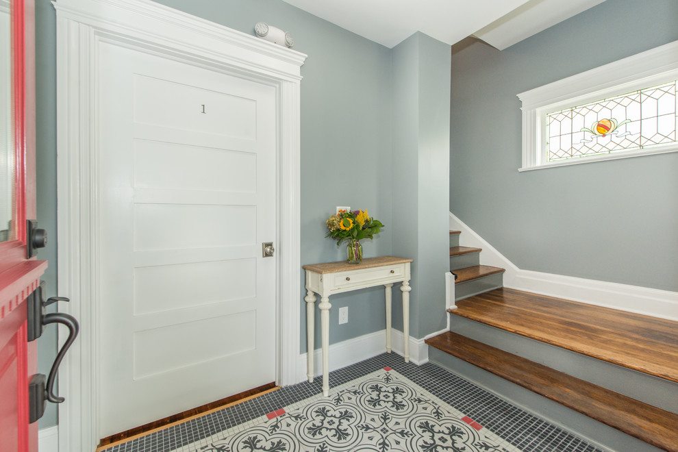 Entryway - mid-sized transitional porcelain tile and black floor entryway idea in New York with gray walls and a red front door