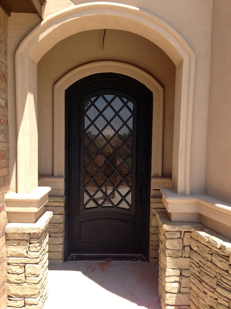 Aménagement d'une porte d'entrée classique de taille moyenne avec un mur beige, sol en béton ciré, une porte métallisée et une porte simple.